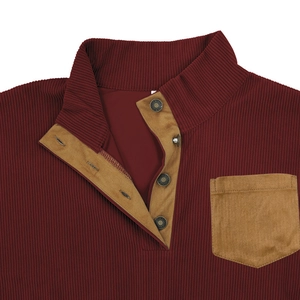 Detail of burgundy corduroy sweatshirt featuring khaki patch pocket and metallic snap buttons