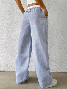 Detail of blue and white striped high-waisted wide-leg trousers with elastic waistband