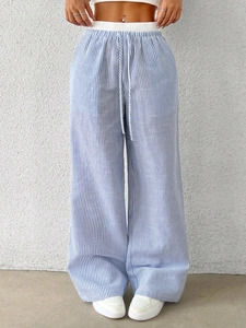 Detail view of high-waist elastic waistband with white drawstring on striped wide-leg pants