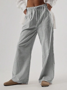 Dettaglio della vita elastica con coulisse e texture a righe verdi dei pantaloni larghi