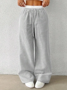Detail of grey striped wide-leg pants with elastic high waist and decorative drawstring