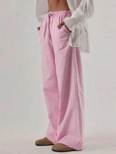 Dettaglio dei pantaloni a gamba larga a righe verticali rosa e bianche con coulisse in vita