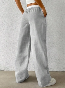 Detail of high waisted wide leg pants featuring grey and white vertical stripes on back