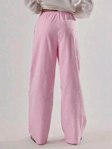 Dettaglio dei pantaloni larghi a righe bianche e rosa con vita elasticizzata