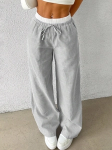 Detail of high-waist striped wide-leg trousers with elastic drawstring waistband