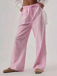 Dettaglio dei pantaloni casual a righe verticali bianche e rosa con coulisse in vita