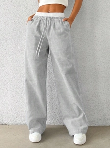 Detail of high waist striped wide leg pants featuring adjustable drawstring and elastic waistband