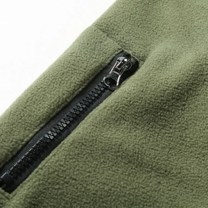 Detail of army green tactical fleece jacket showing the black nylon zipper and metal puller