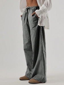 Dettaglio dei pantaloni larghi a righe con vita elastica a coulisse e motivi verticali rifiniti