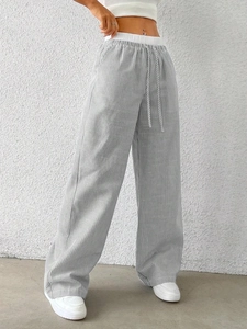Detail of grey striped wide-leg pants featuring white elastic waistband and drawstring