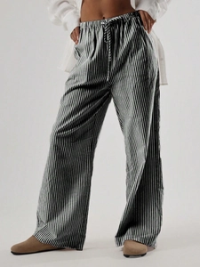 Dettaglio dei pantaloni a gamba larga a righe bianche e nere con coulisse in vita