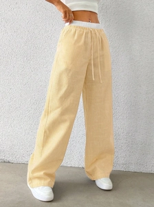 Detailed view of yellow and white striped wide-leg pants with adjustable white drawstring