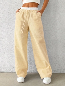 Detail of light yellow vertical stripe wide leg trousers with elastic drawstring waist