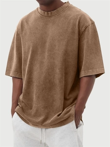 Detail of heavyweight washed cotton fabric and ribbed crewneck on men's vintage brown t-shirt