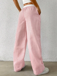 Detail of pink vertical stripes and elastic waistband on relaxed wide-leg trousers