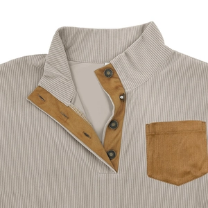 Detail of corduroy texture and contrasting brown suede pocket on a men's henley top