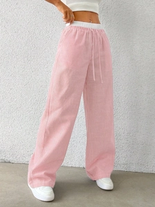 Detail of high-waisted pink and white vertical striped wide-leg pants with elastic drawstring