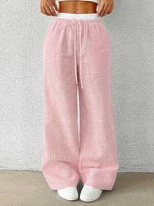 Detail of high-waisted pink striped wide-leg pants with drawstring and linen texture