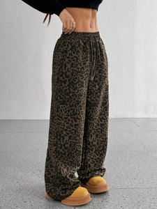 Dettaglio dei pantaloni leopardati a vita alta con gamba larga e coulisse regolabile