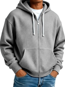 Detail of gray waffle knit hoodie for men featuring metal zipper and front pockets