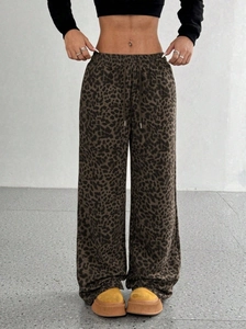 Dettaglio dei pantaloni leopardati a vita alta e gamba larga con coulisse e maglia morbida