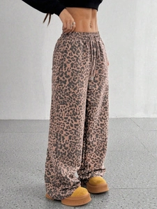 Dettaglio dei pantaloni a gamba larga con stampa leopardata e vita alta regolabile