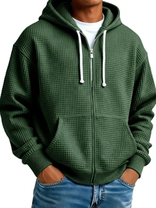Close-up of deep green waffle-knit fabric detail and sturdy zipper on men's hoodie