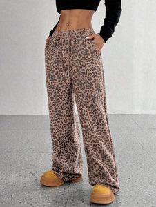Dettaglio dei pantaloni leopardati a vita alta con gamba larga e coulisse elastica