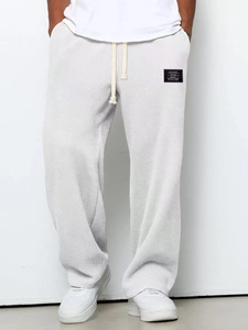 Dettaglio del tessuto a nido d'ape grigio chiaro sui pantaloni casual da uomo con lacci