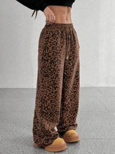 Dettaglio dei pantaloni a vita alta con stampa leopardata, gamba larga e coulisse in vita