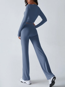 Side view of steel blue two-piece yoga set showing long sleeve top and flared leggings