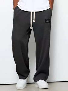 Detail of dark grey waffle texture lounge pants with drawstring and classic wear patch