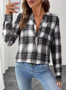 Detail of classic black and white plaid shirt with metal buttons and buttoned cuffs