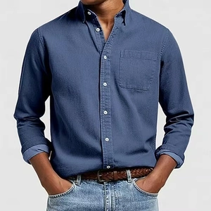 Dettaglio camicia da uomo blu denim a maniche lunghe con colletto button-down e taschino
