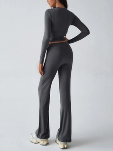 Close-up of high-waisted flared leggings and slim fit crop top in dark grey knit fabric
