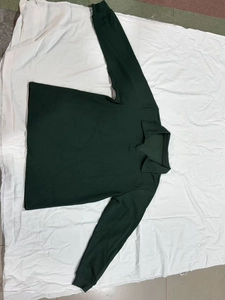 Detailansicht der dunkelgrünen Waffelstrick-Textur und der Rippbündchen am Polo-Pullover