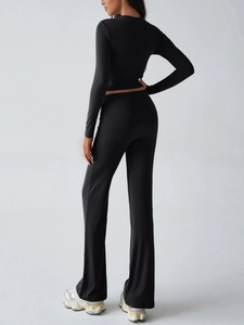Detail of the high-elastic black fabric texture on slim fit yoga top and flared pants