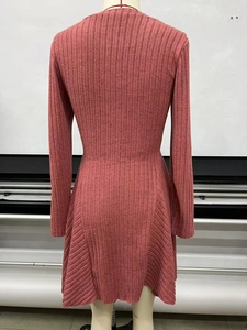 Detail view of the ribbed knit texture and flared hem on a dusty pink long sleeve dress