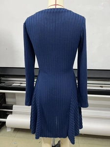 Detail of navy knit long sleeve dress showing ribbed texture and diagonal weave patterns