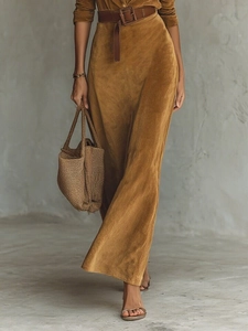 Macro detail of caramel suede shirt dress texture with a vintage brown leather waist belt