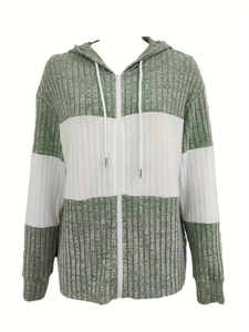 Detail van groen-witte hoodie met kleurblokken en geribbelde textuur met rits