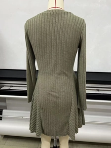 Detail view of the olive green ribbed knit fabric and A-line hem on the long sleeve dress