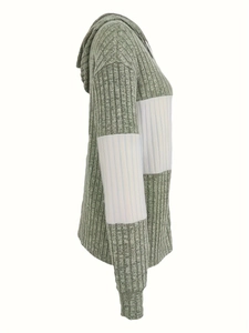 Detail van saliegroene ribgebreide stof en witte zijpanelen op de hoodie jas