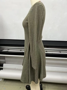 Detailed texture of olive green ribbed knit long sleeve dress with premium stitching
