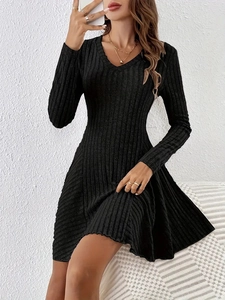 Detail of the V-neckline and ribbed knit texture on the elegant black long sleeve dress