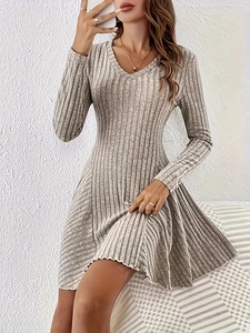 Close-up of oatmeal v-neck knitted dress featuring ribbed texture and flare skirt hemline