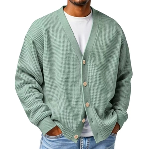 Detail of sage green waffle knit texture and wooden buttons on men's V-neck cardigan