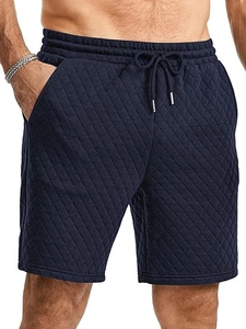 Detail of navy blue quilted texture fabric on men's casual drawstring shorts