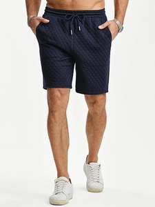 Close-up of diamond quilted texture and drawstring waist on navy blue men's casual shorts