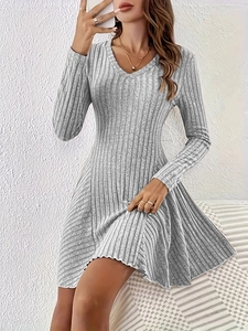 Macro detail of grey ribbed knit fabric texture on V-neck long sleeve dress